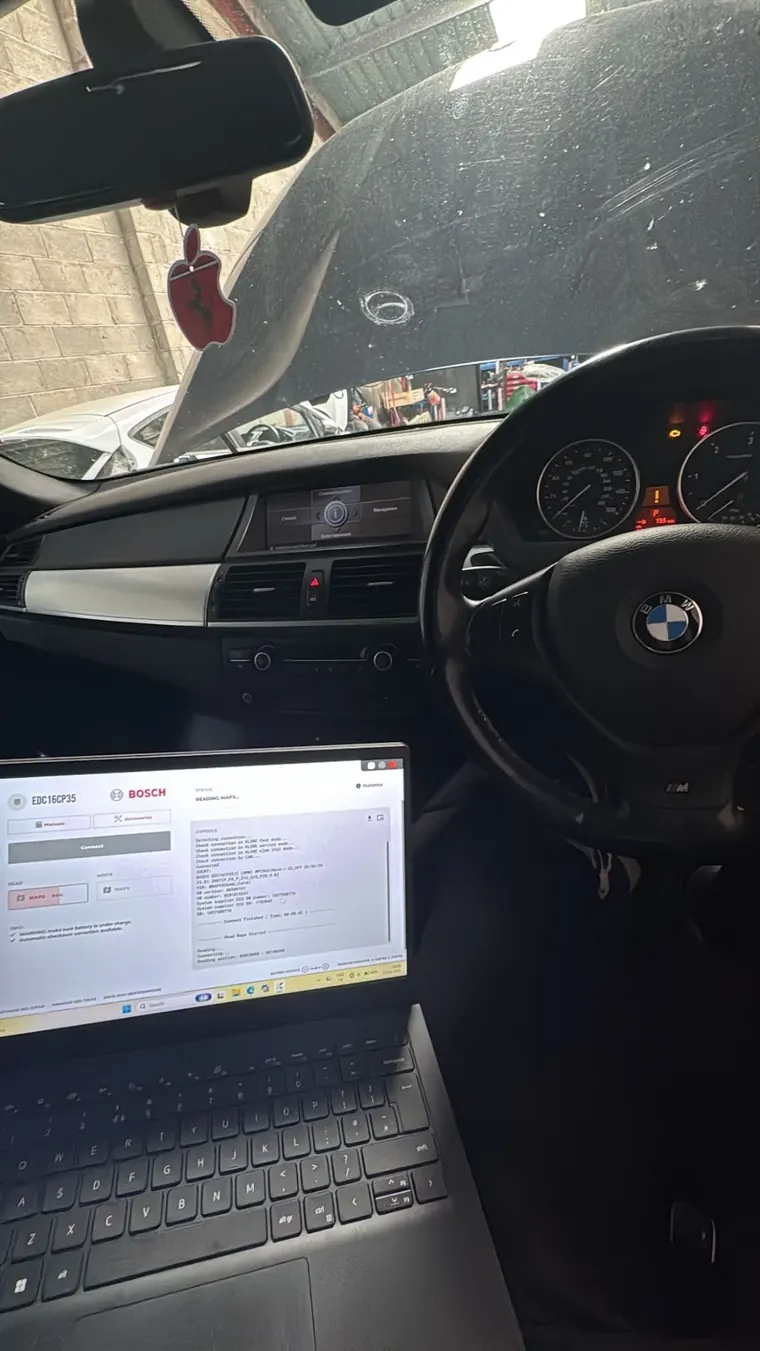 BMW interior with a laptop displaying ECU remapping software