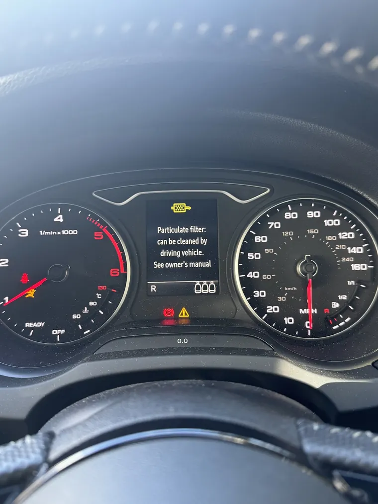 Vehicle dashboard displaying a diesel particulate filter warning message